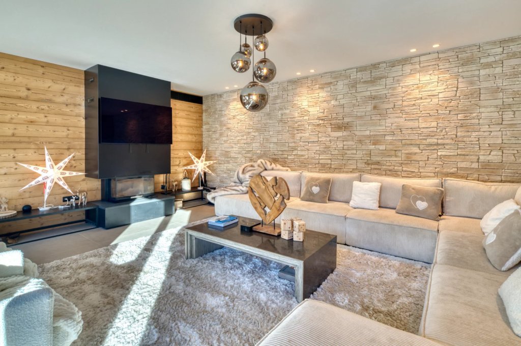 Salon avec cheminée en pierre naturelle, chalet luxe Alpes du Sud