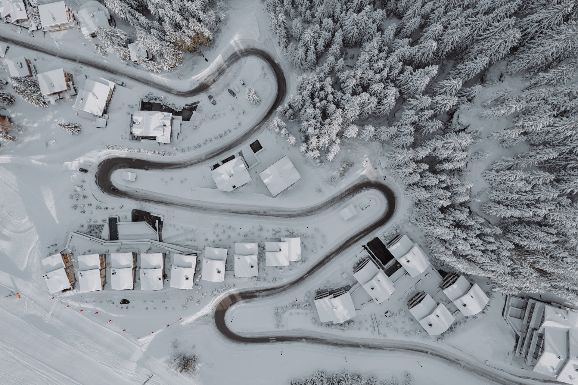 Vue aérienne en plongée du Hameau Courchevel, treize chalets sur les pistes des Trois Vallées