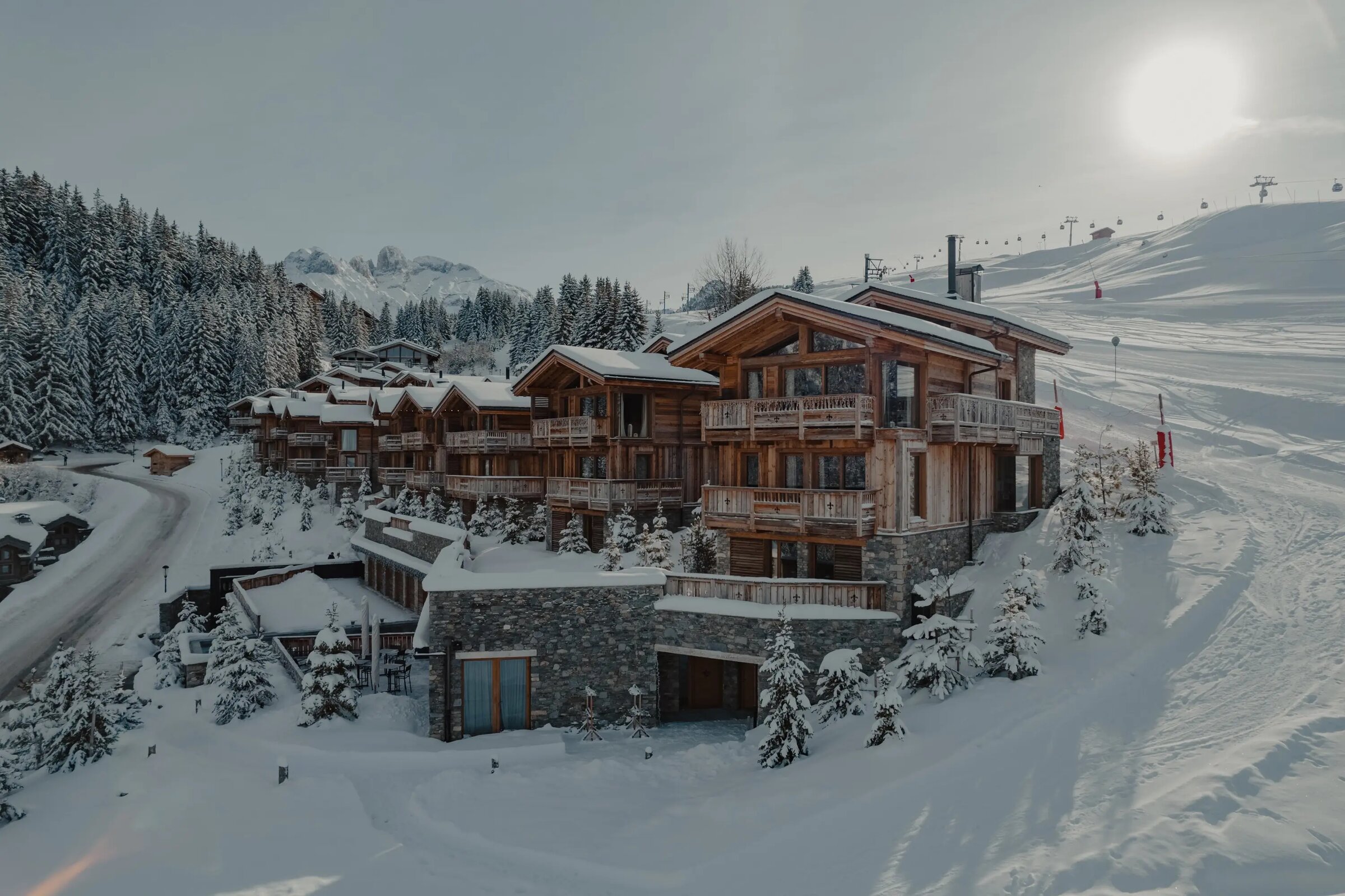 Hameau Courchevel ski-in/ski-out, chalets posés sur les pistes avec remontées mécaniques en arrière-plan
