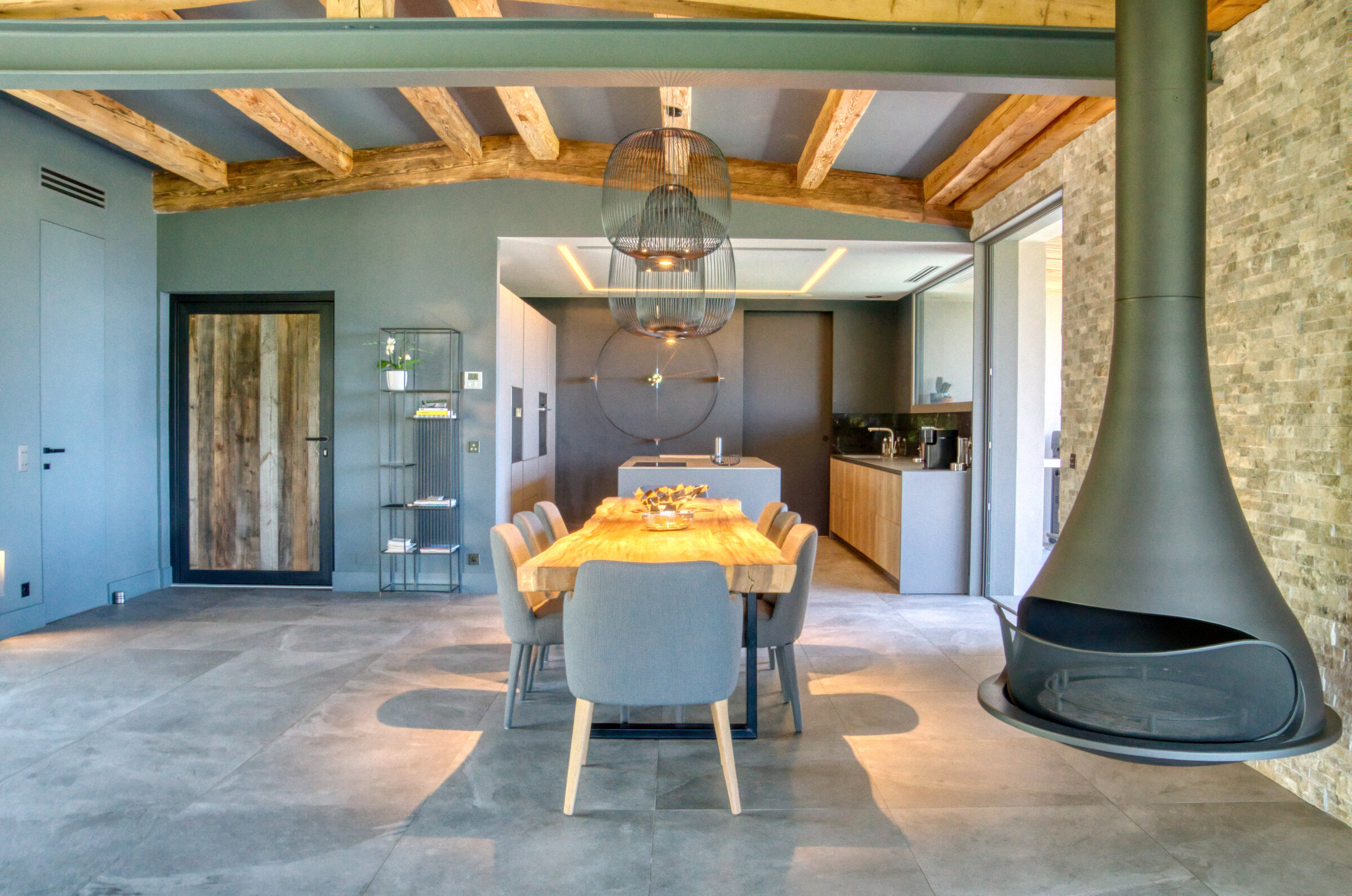Salle à manger avec cheminée flottante suspendue et poutres anciennes, Villa Bali Cannes