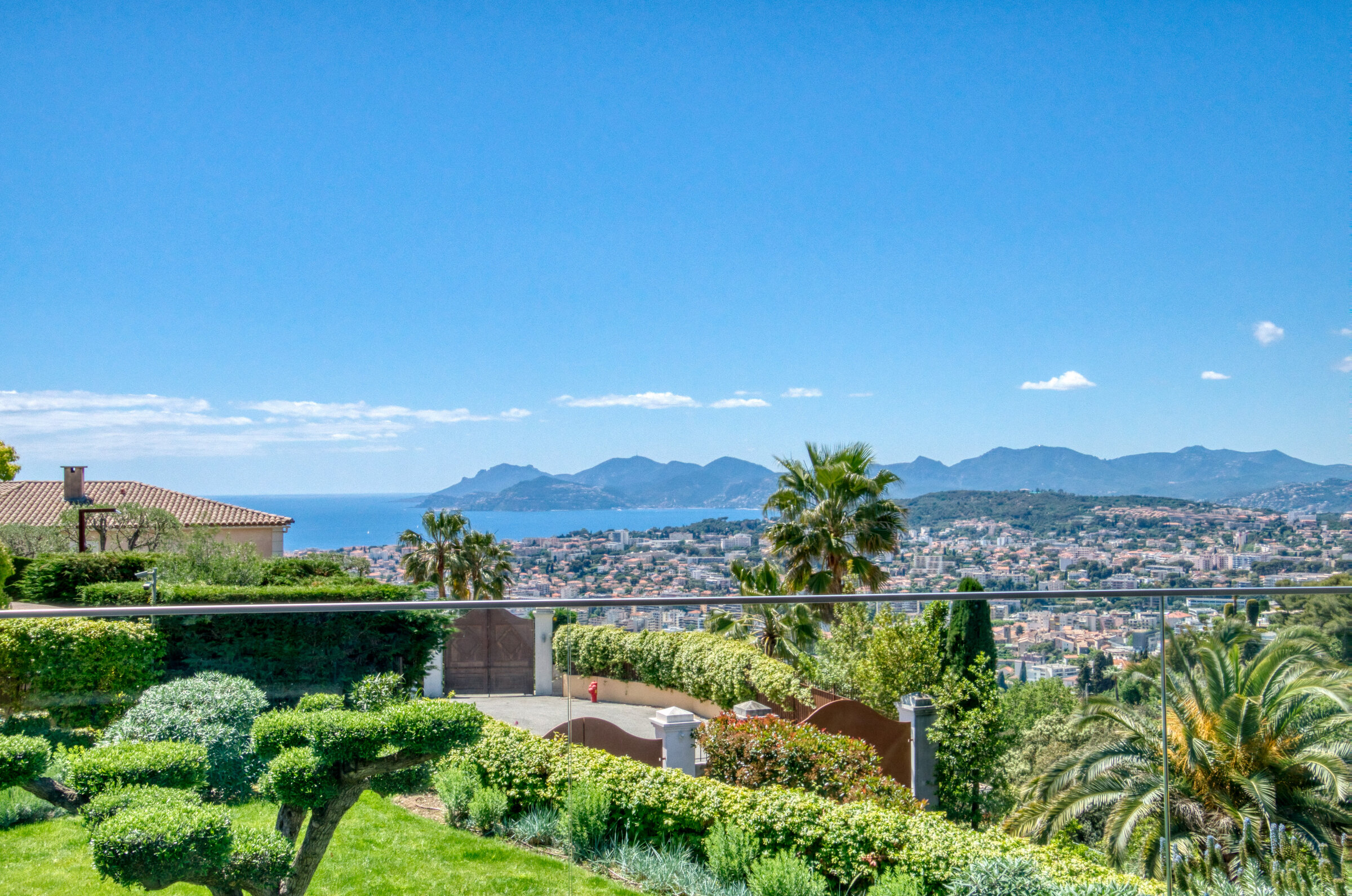 Terrasse avec topiaires, palmiers et vue traversante sur Cannes, Villa Bali