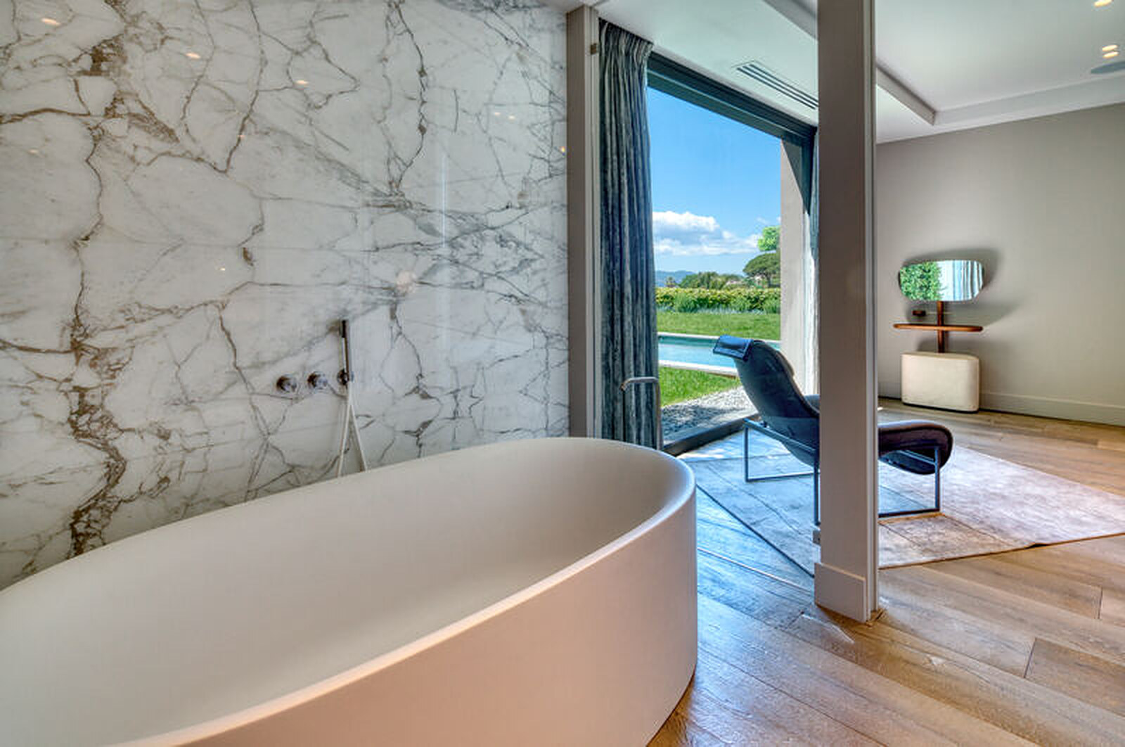 Salle de bain master avec baignoire ovale en marbre Calacatta et vue sur le jardin, Villa Bali