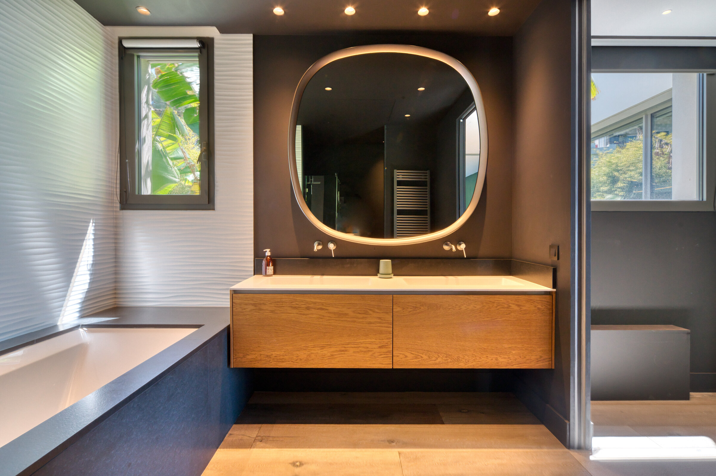 Salle de bain design avec miroir rond et vasque flottante en bois, Villa Bali